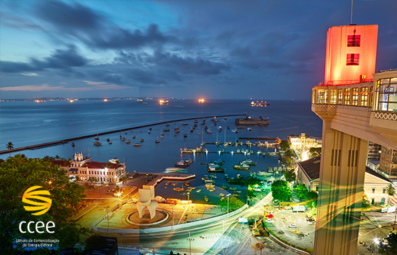 Imagem da região do Elevador Lacerda, em Salvador. Imagem pega ao fundo a Baía de Todos os Santos, com barcos atracados e, no canto direito, em primeiro plano, o Elevador Lacerda. 