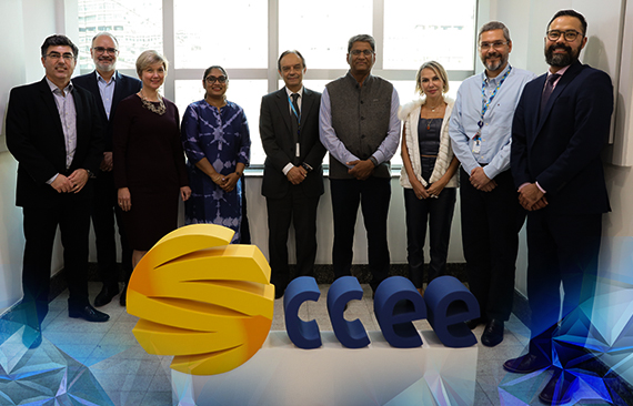 A imagem mostra os conselheiros da CCEE e os representantes do comitê indiano em frente ao logo da Câmara de Comercialização