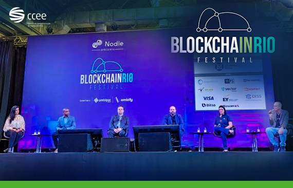 A imagem mostra o palco do Bockchain Rio Festival 2022, com os participantes do painel sentados em cadeiras, em frente a um fundo azul