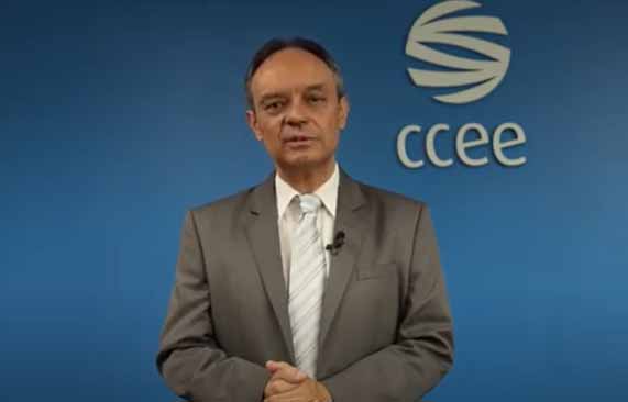 Presidente Rui Altieri de terno com logo da CCEE no fundo