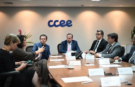 A imagem mostra o ministro Alexandre Silveira e o presidente do Conselho de Administração da CCEE, Alexandre Ramos, em uma mesa com outros executivos.