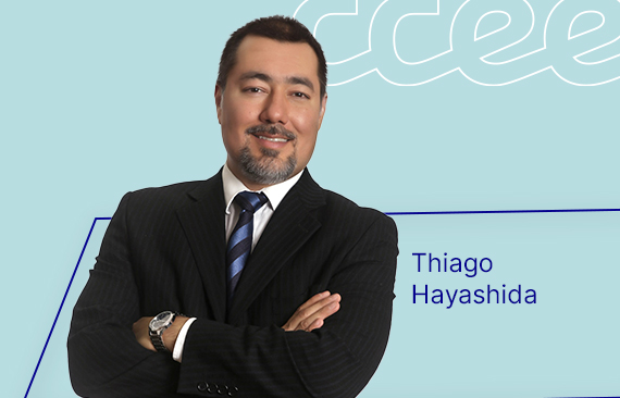 Retrato de Tiago Hayashida, Gerente Executivo da CCEE. Ele é um homem asiático, de cabelos pretos e veste um terno cinza escuro.