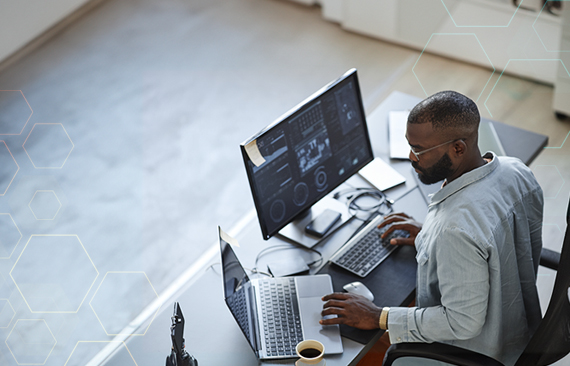 Imagem de um homem negro que trabalha com seu computador em um escritório