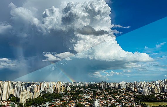 Cidade parcialmente encoberta por chuva ao mesmo tempo em que está ensolarada