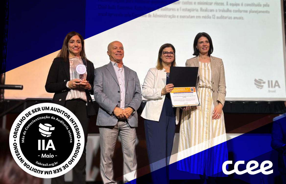 Quatro pessoas posando para foto segurando um troféu.