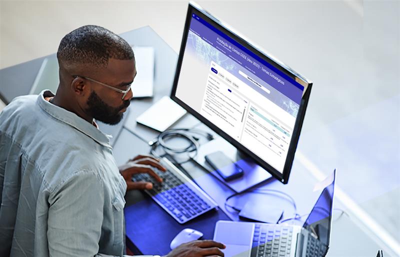 homem na frente do computador utilizando o painel