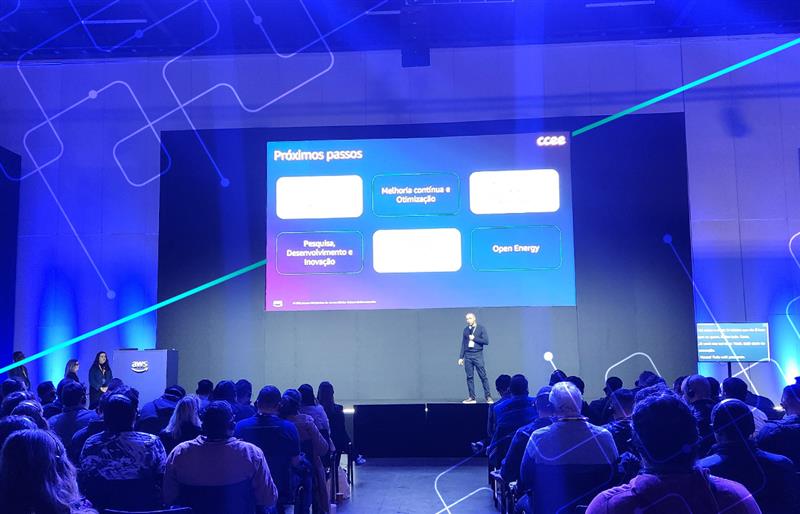 Imagem mostra colaborador da CCEE no palco do AWS Summit 2025 apresentando.