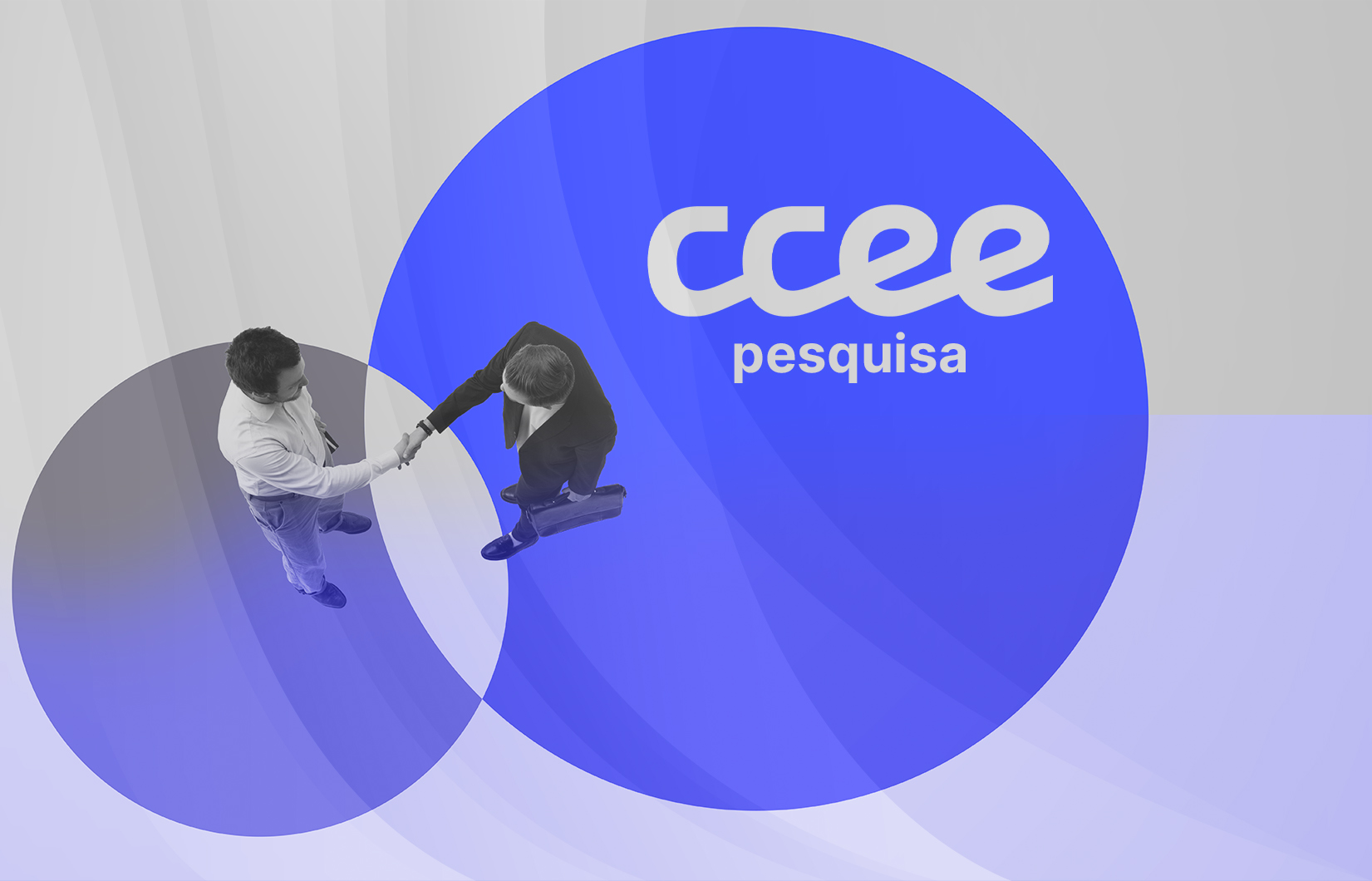 Visão aérea de dois executivos, que trajam roupas sociais, apertando as suas mãos.